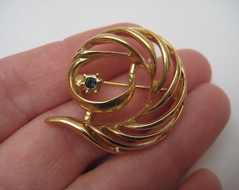 Broche tourbillon vintage des années 1950 dorée avec pierre bleue