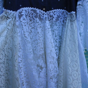 May include: A white lace dress with a denim bodice. The lace is a delicate floral pattern and the denim is a dark blue colour.