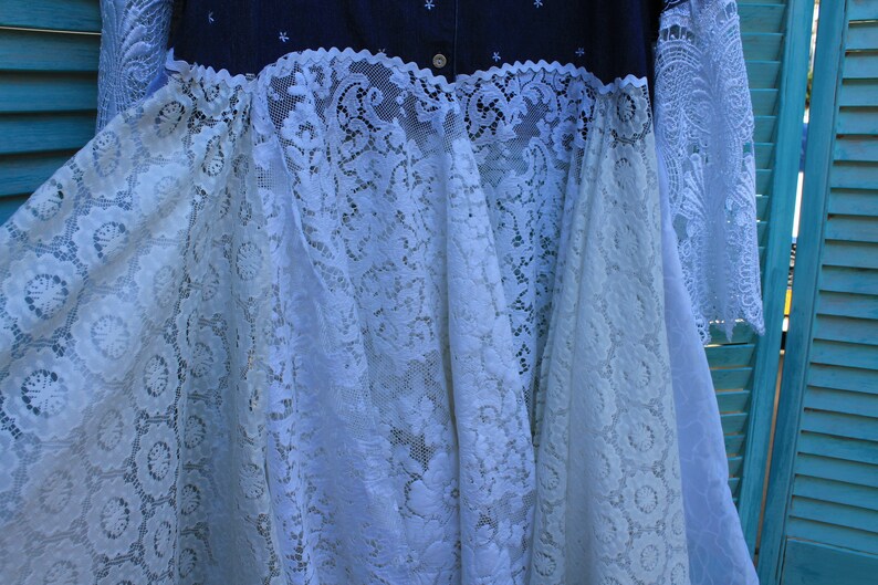 May include: A white lace dress with a denim bodice. The lace is a delicate floral pattern and the denim is a dark blue colour.