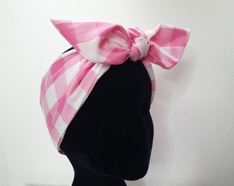 May include: Pink and white gingham headband tied in a bow. The headband is on a black mannequin head.