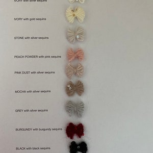 K&ouml;nnte beinhalten: Eine Sammlung kleiner, flauschiger Schleifen in verschiedenen Farben, jede mit Pailletten verziert. Farben sind Wei&szlig;, Elfenbein, Stein, Pfirsichpuder, rosa Staub, Mokka, Grau, Burgunderrot, Schwarz und Hellblau. Der Text zeigt die Farbe und die Farbe der Pailletten an.