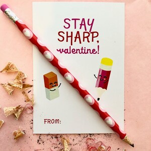 Puede incluir: Una tarjeta blanca con corazones rojos y rosas impresos en ella. La tarjeta dice "Stay Sharp, valentine!" con un borrador y un lápiz de dibujos animados. La tarjeta tiene un espacio para un nombre en la parte inferior que dice "From:"