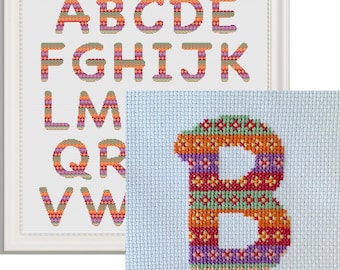 May include: A framed cross-stitch pattern of the alphabet in colorful stripes. The letter B is also shown in a separate frame, stitched in the same colorful striped pattern.