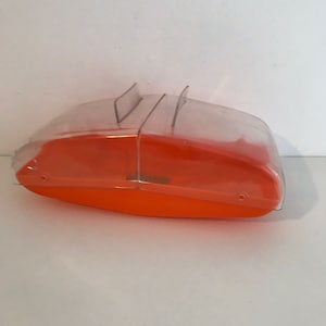 May include: Orange plastic storage box with a clear plastic lid. The lid has two flaps that can be folded down to secure the box.