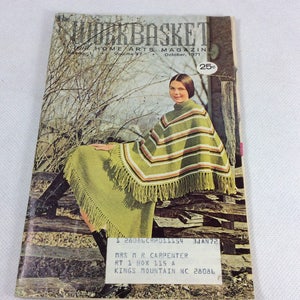 May include: A vintage magazine cover featuring a woman wearing a green and brown striped poncho with fringe. The magazine is called "The Workbasket Home Arts Magazine" and the cover price is 25 pence. The magazine is dated October 1971.
