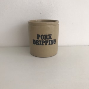 以下が含まれることがあります： 黒い文字で「PORK DRIPPING」と書かれたベージュの陶器の壺
