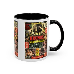 May include: A white ceramic mug with a black interior and handle, featuring a vintage movie poster graphic for Kronos Reenergized. The design includes a large black cube-shaped machine, red and yellow text, and illustrations of people in distress.
