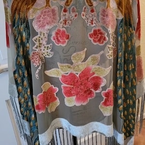 Peut inclure: Un châle en voile gris avec un motif de paon en velours et des accents floraux. Le châle a une bordure à franges et est fait d'un tissu léger.