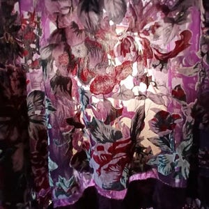 Peut inclure: Tissu transparent violet avec un motif floral dans des tons de rouge, bleu et blanc. Le tissu a une texture délicate, presque semblable à de la dentelle.