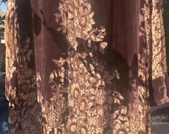 May include: A long, dark brown velvet coat with a floral pattern in a lighter brown color. The coat has long sleeves and a collar. The floral pattern is concentrated in the center and along the edges.