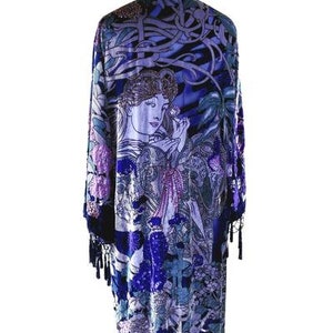 Peut inclure: Un long kimono fluide dans les tons de bleu, violet et noir, orné d'une illustration d'une femme d'inspiration Art nouveau. Le vêtement est orné de franges le long de l'ourlet et des manches, créant une esthétique bohème.
