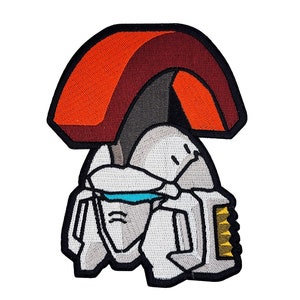 May include: An embroidered patch featuring a cartoon robot head with a red and brown helmet and a white face. The robot has a blue visor and a gold and black weapon.