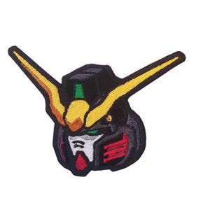 Peut inclure: Patch brodé représentant une tête de robot de dessin animé avec une antenne jaune et noire, des yeux verts et un visage rouge et noir. La tête du robot est sur un fond blanc.