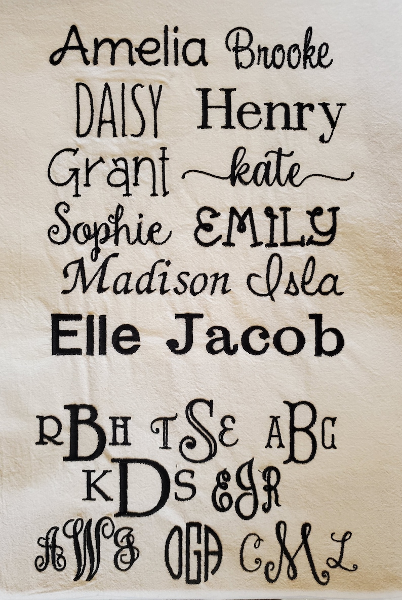 May include: A white fabric with black embroidered names, including Amelia, Brooke, Daisy, Henry, Grant, Kate, Sophie, Emily, Madison, Isla, Elle, and Jacob. The fabric also has black embroidered letters, including R, B, H, T, S, E, A, B, G, K, D, S, &, J, R, A, W, I, O, G, A, C, M, and L.