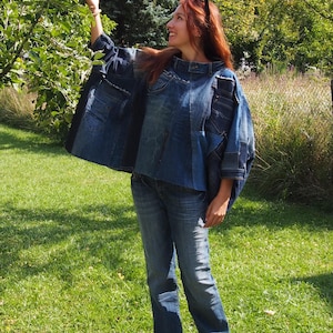 Op de afbeelding: Een blauw denim patchwork jack met een breed, boxy silhouet met zichtbare naden, gerafelde randen en meerdere denim zakpanelen. Het jack wordt gecombineerd met een bijpassende blauwe spijkerbroek met een rechte snit en een klassieke wassing.