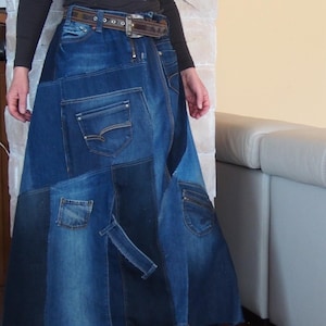 Op de afbeelding: Een patchwork denim rok in verschillende blauwtinten. De rok heeft meerdere denim patches, zakken en een bruine riem. De rok is een uniek, handgemaakt stuk.