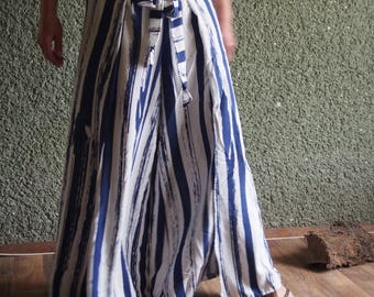 Può includere: Un paio di pantaloni a gamba larga con un motivo a righe bianche e blu. I pantaloni hanno un laccio in vita e sono realizzati in un tessuto leggero.