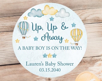 May include: A blue and yellow baby shower announcement with hot air balloons and stars. The text reads "Up, Up & Away A Baby Boy is on the Way! Lauren's Baby Shower 03.15.2040"