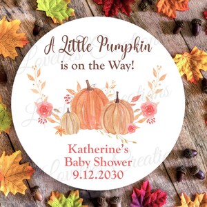 May include: A white round sticker with a fall theme. It says "A Little Pumpkin is on the Way!" with a watercolor illustration of pumpkins and fall leaves. The text "Katherine's Baby Shower 9.12.2030" is at the bottom.