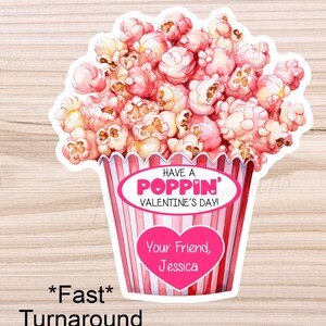 May include: A pink and white striped popcorn bucket with the text "HAVE A POPPIN' VALENTINE'S DAY!" and a pink heart with the text "Your Friend, Jessica".