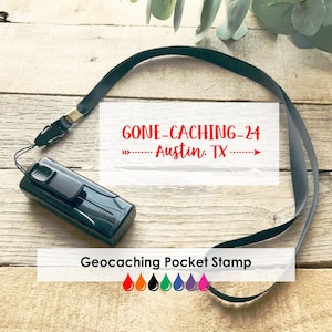 May include: A black geocaching pocket stamp with a black lanyard. The stamp has the text "GONE-CACHING-24 Austin, TX" in red. The image also includes a color palette of orange, red, black, green, blue, purple, and pink.
