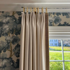 May include: White curtains with gold curtain rods and a brown trim. The curtains are hung in front of a window with a view of a green lawn.