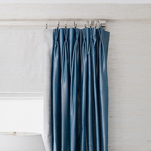 a blue curtain hanging on the side of a window