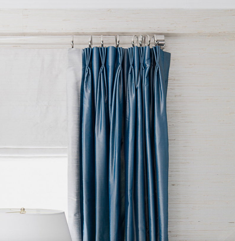 a blue curtain hanging on the side of a window