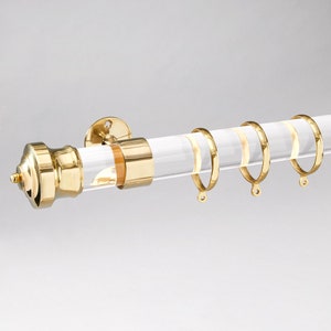 Round acrylic drapery rod with imperial style finial/end cap in polished brass gold finish.