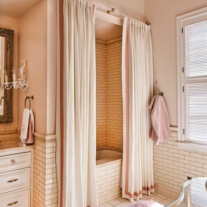 a bath room with a tub a mirror and a window