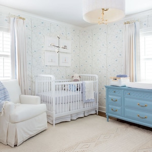 a baby's room with a blue dresser and a white crib