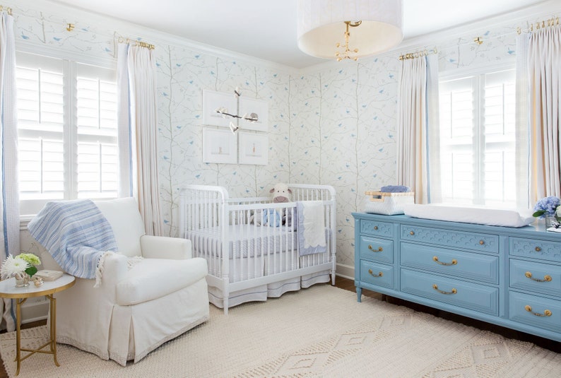 a baby's room with a blue dresser and a white crib