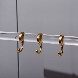 a pair of gold rings hanging from a metal bar