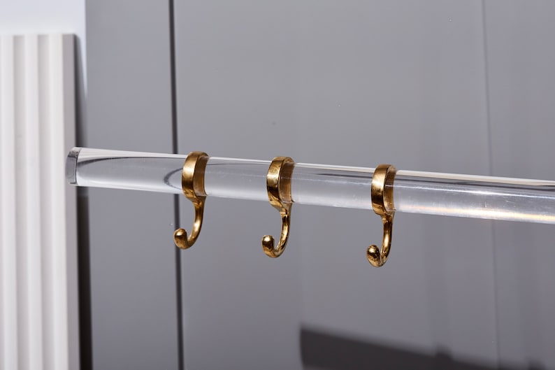 a pair of gold rings hanging from a metal bar