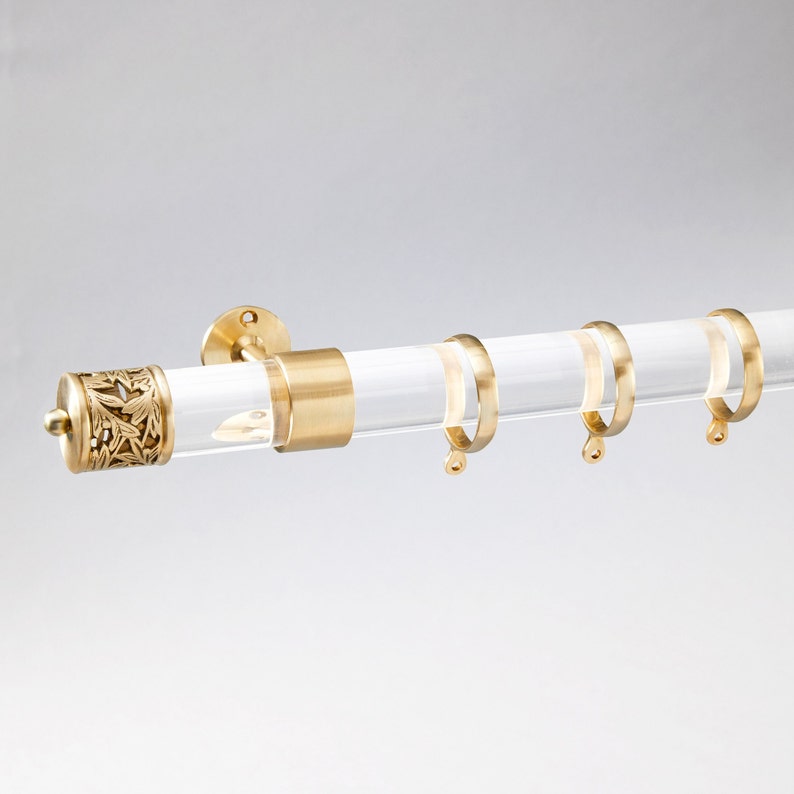 Round acrylic drapery rod with lattice style finial/end cap in satin brass finish.