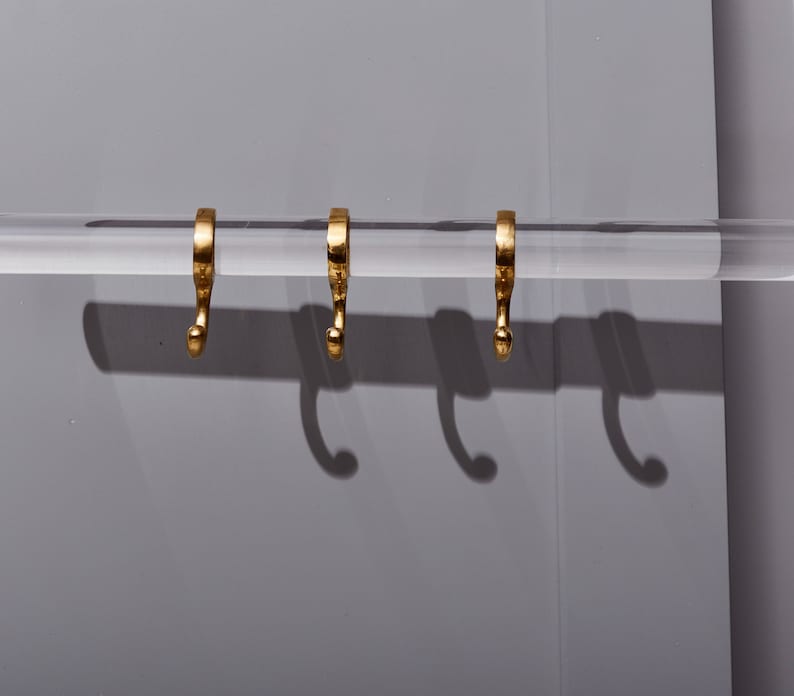 a pair of gold earrings hanging from a hook