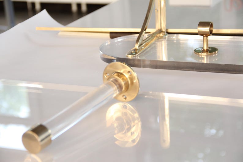 a close-up view of a transparent brass piece with a reflective surface, placed on a white surface.