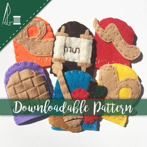 Pode incluir: Um conjunto de sete fantoches de dedo de feltro que representam vários símbolos da festa judaica da Páscoa. Os fantoches incluem um matzá, um shofar, uma uva, um pote de mel, uma maçã, um rolo da Torá e um chalá.