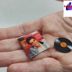 Pu&ograve; includere: Un disco in vinile in miniatura e una copertina dell'album con Elvis Presley. La copertina dell'album &egrave; rossa e presenta una foto di Elvis Presley. Il disco &egrave; nero con un'etichetta dorata.