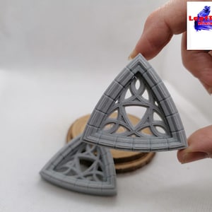 Peut inclure: Deux cadres de fenêtres gothiques triangulaires gris avec des motifs complexes. Les cadres sont faits d'un matériau texturé et ont un bord légèrement surélevé.