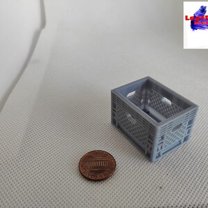 May include: A small gray plastic crate, about the size of a US penny, for miniature crafts and model making.