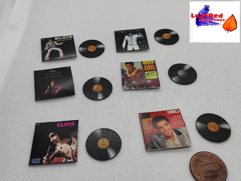 Pu&ograve; includere: Una collezione di album in miniatura di Elvis Presley e 45 giri. Gli album presentano diverse copertine di album con Elvis sul davanti. I 45 giri sono neri con un'etichetta dorata. Gli album sono tutti in miniatura e sono disposti in una griglia.