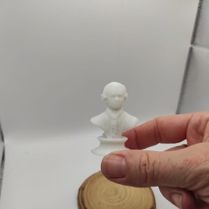 May include: A white 3D printed bust of a person with a simple base.