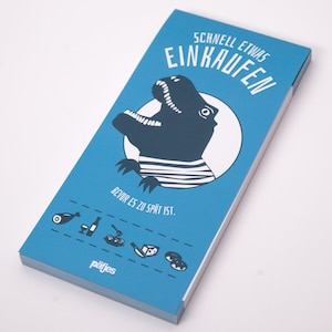 Peut inclure: Un bloc-notes bleu avec un dinosaure de dessin animé portant une chemise rayée dans un cercle blanc. Le bloc-notes contient le texte allemand "SCHNELL ETWAS EINKAUFEN" et "BEVOR ES ZU SPÄT IST." avec des icônes d'aliments.