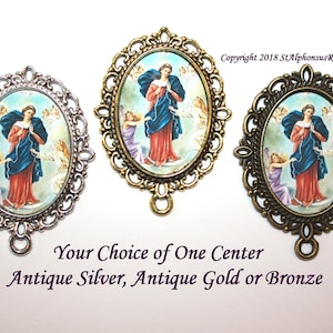 May include: Three oval-shaped medallions with a religious image of the Virgin Mary, also known as Our Lady, Undoer of Knots. The medallions are in antique silver, antique gold, and bronze finishes. The image shows Mary holding a rope with knots, surrounded by angels. The text "Copyright 2018 StAlphonsusRosary" is visible in the top right corner. The text "Your Choice of One Center Antique Silver, Antique Gold or Bronze" is visible at the bottom of the image.