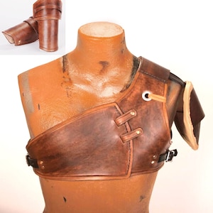May include: Brown leather shoulder armour with straps and buckles. The armour is worn on a mannequin.