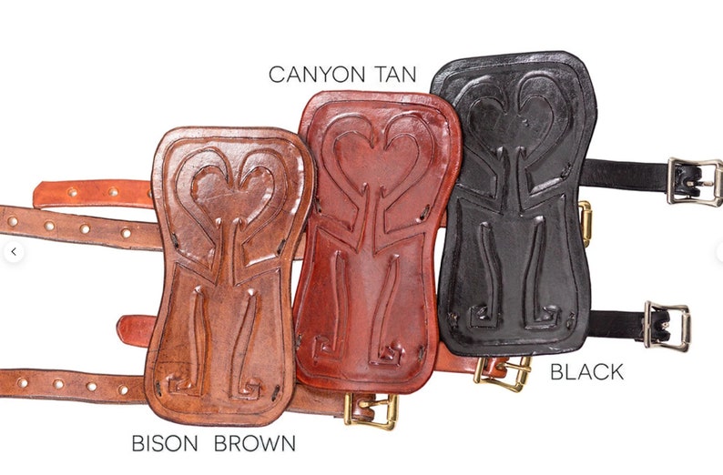Puede incluir: Tres protectores de brazo de cuero con tallas decorativas. Los protectores de brazo son de color marr&oacute;n bisonte, marr&oacute;n ca&ntilde;&oacute;n y negro. Cada protector de brazo tiene una hebilla y una correa.