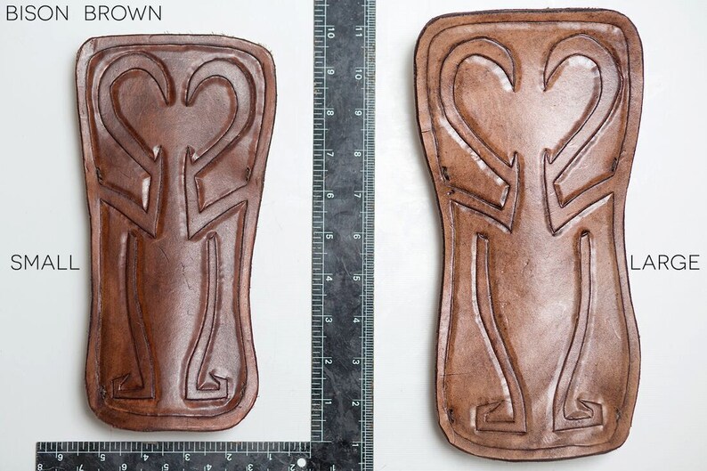 Puede incluir: Dos parches de cuero en color marr&oacute;n bisonte, uno etiquetado como "peque&ntilde;o" y el otro como "grande". Ambos parches presentan un dise&ntilde;o decorativo con dos formas de coraz&oacute;n.