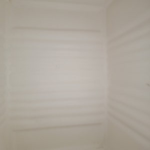 May include: The inside of a white plastic storage container with a smooth, textured surface.