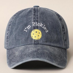 K&ouml;nnte beinhalten: Eine dunkelblaue Baseballkappe aus Denim mit dem in Wei&szlig; gestickten Text "I'm Pickled" und einem in der Mitte gestickten gelben Pickleball.